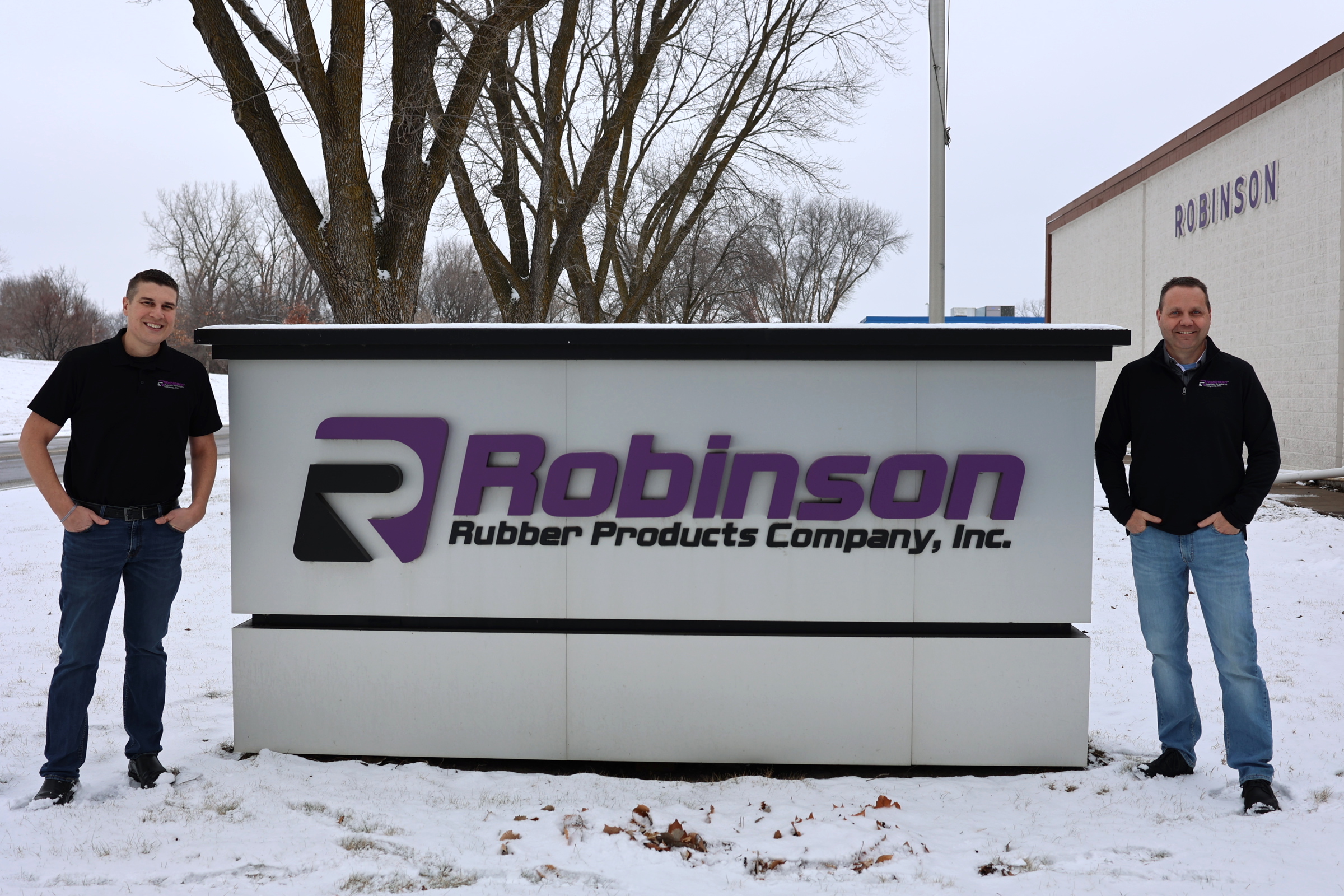 Robinson Rubber Owner Owner Pete Wolf next to Robinson Rubber sign